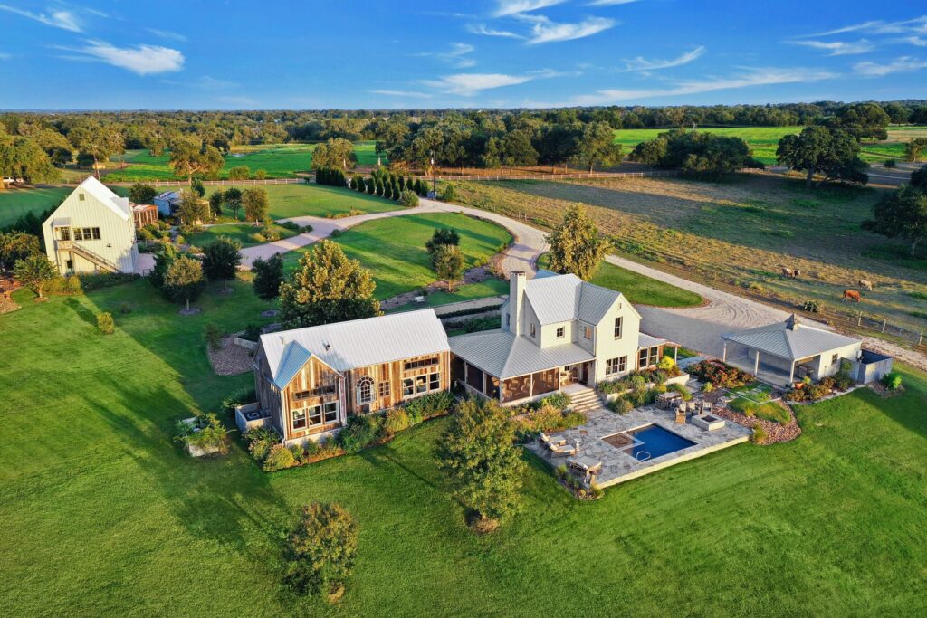 Aerial view of rural estate with pool and surrounding fields