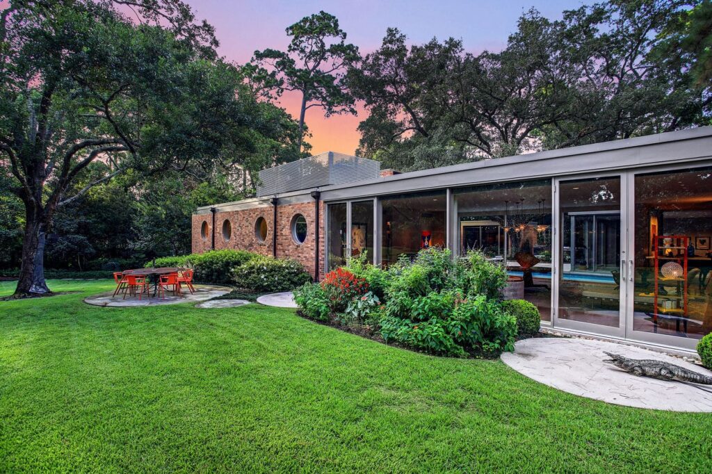 Modern home exterior with landscaped backyard at dusk