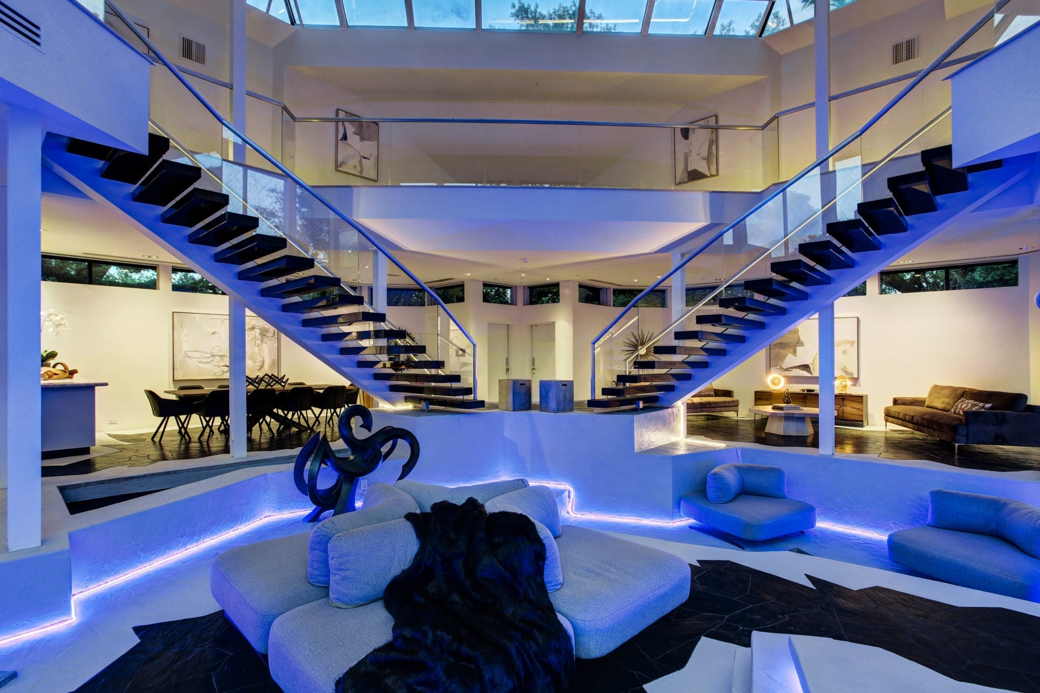 Modern luxury interior with floating staircases and blue accent lighting