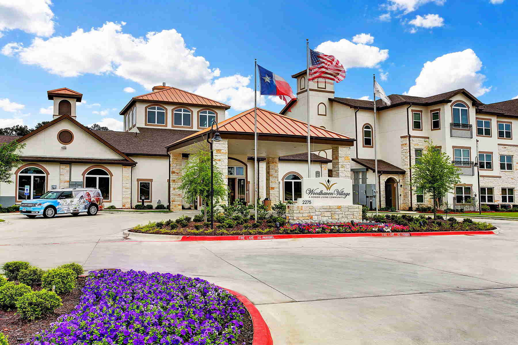 Senior living community exterior with landscaped entrance