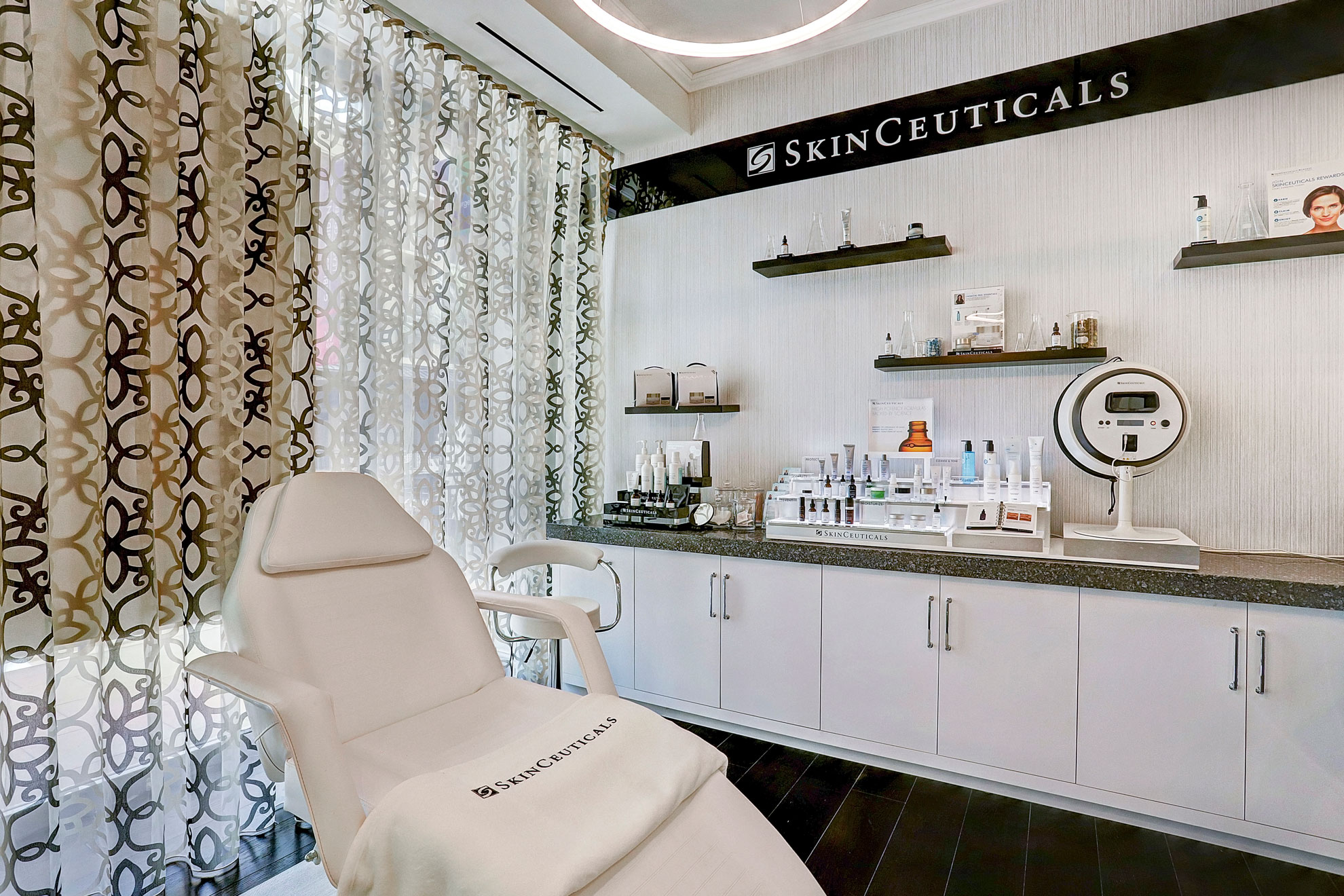 Modern skincare treatment room with product displays and treatment chair