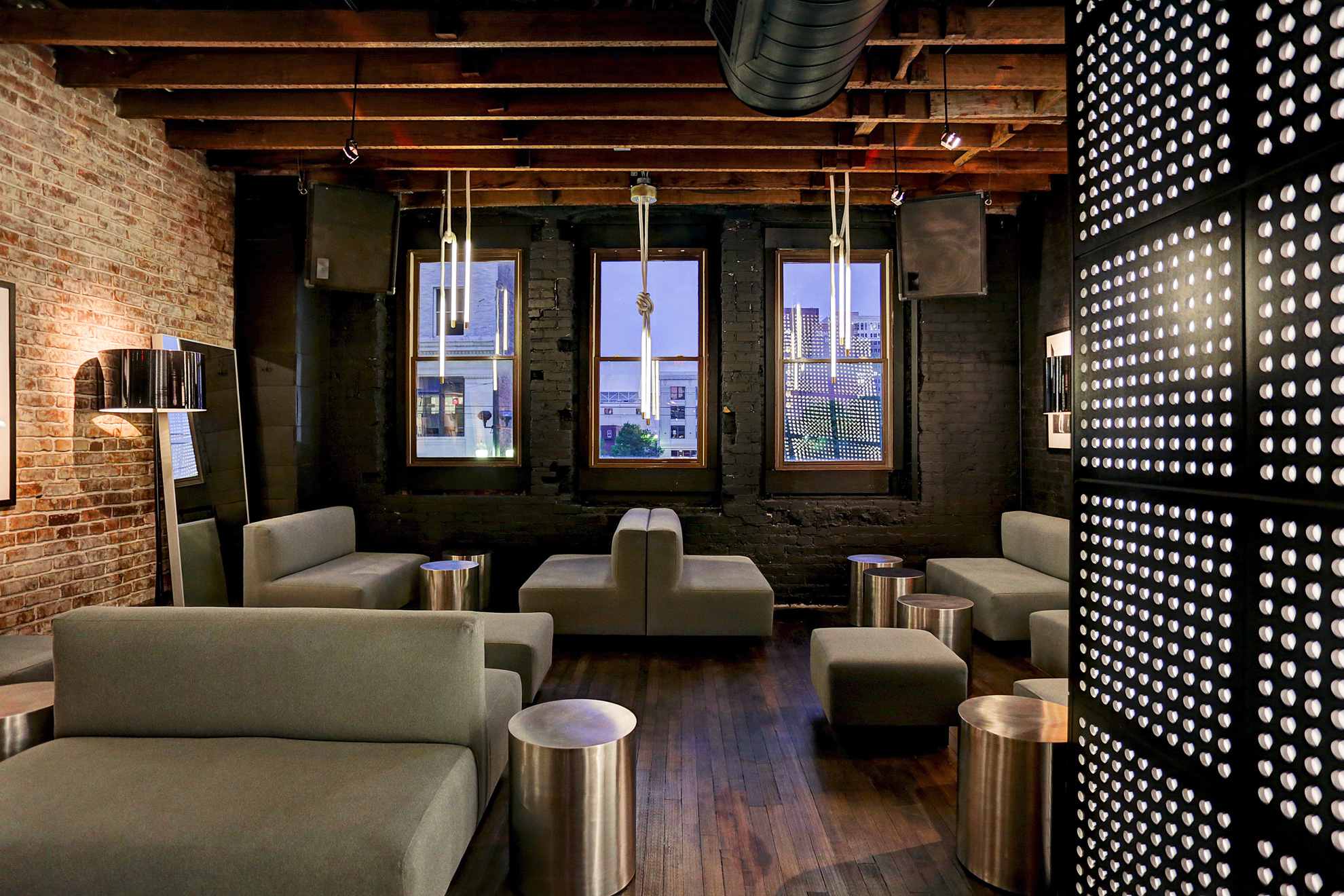 Industrial-style lounge with exposed brick, modern seating, and pendant lights