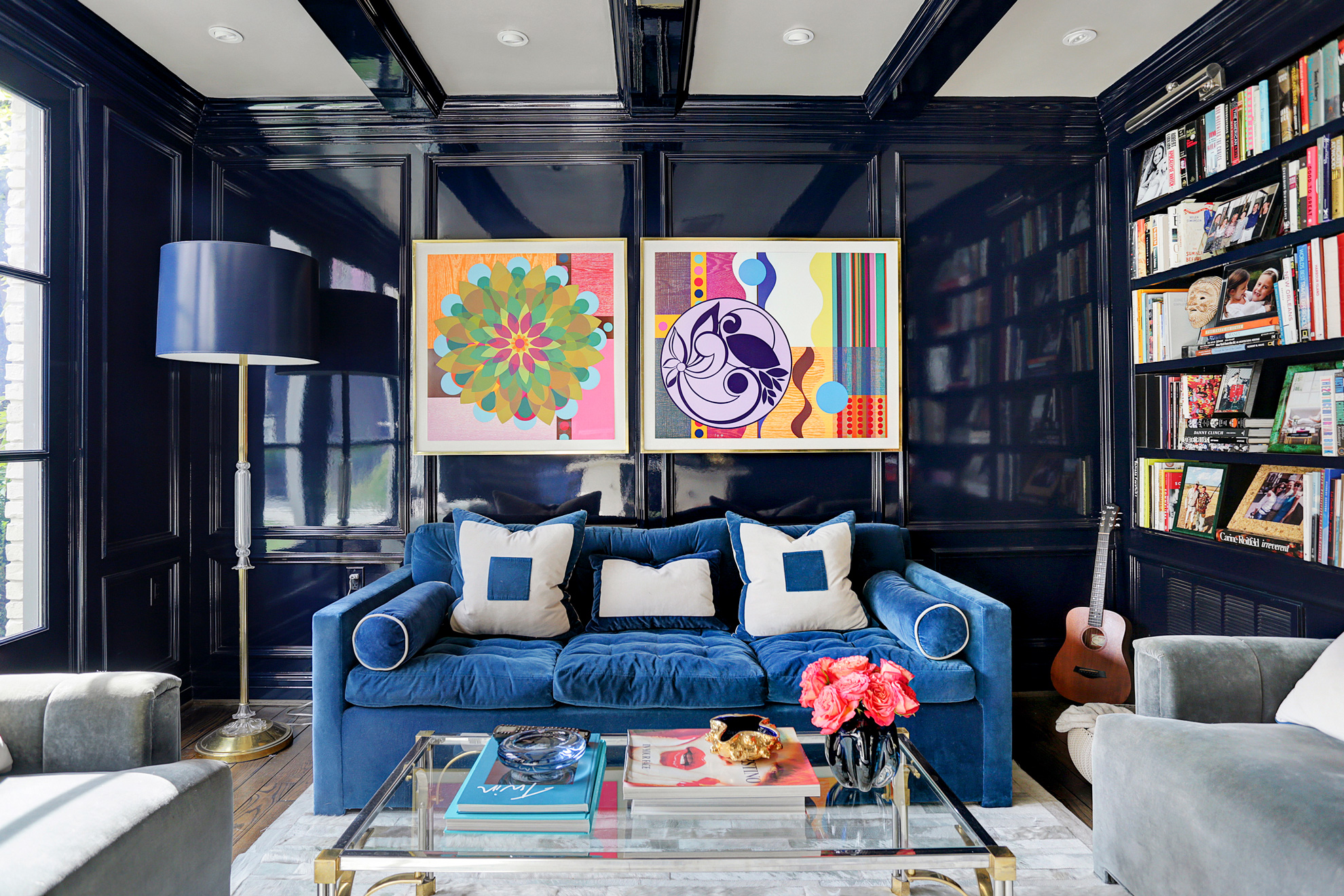 Stylish lounge with blue sofa, artwork, and built-in bookshelves