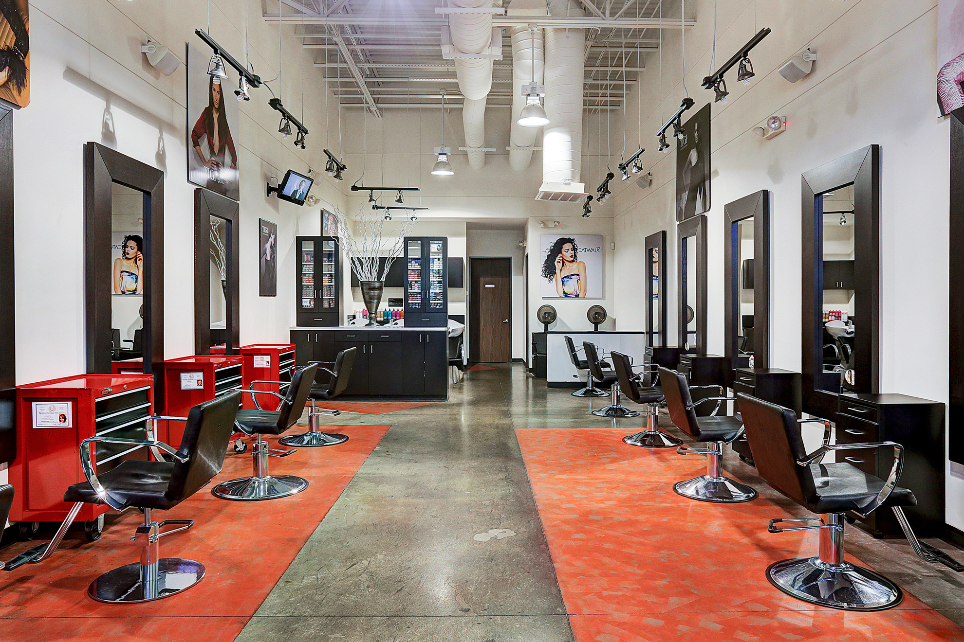 Modern hair salon with styling chairs, mirrors, and open floor space