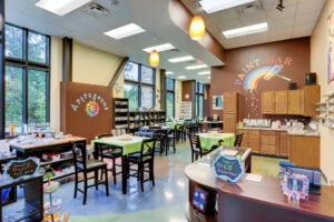 Bright art studio with worktables, supplies, and a colorful paint bar
