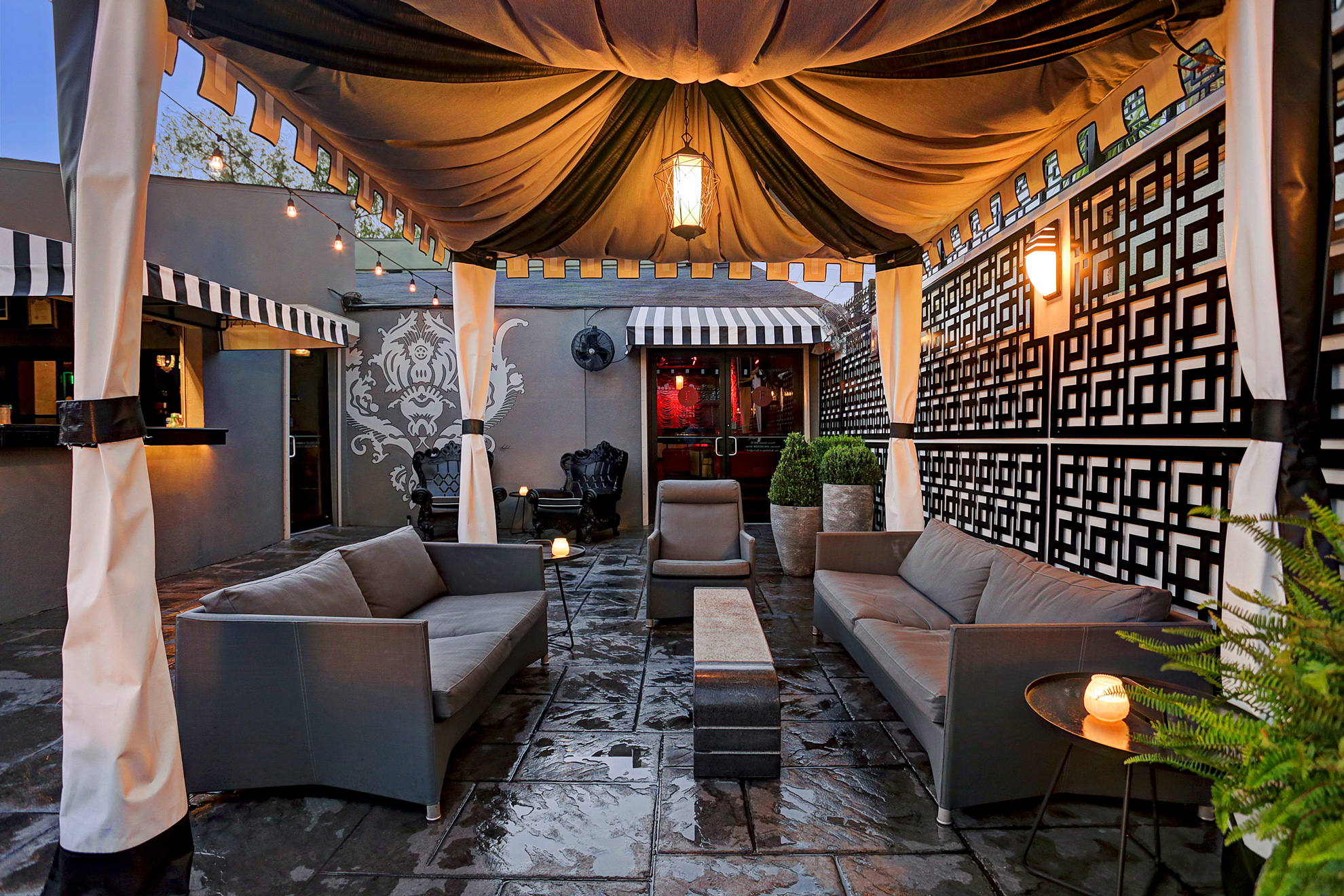 Covered outdoor lounge with sofas and ambient lighting