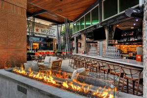Outdoor restaurant bar with seating and a fire feature